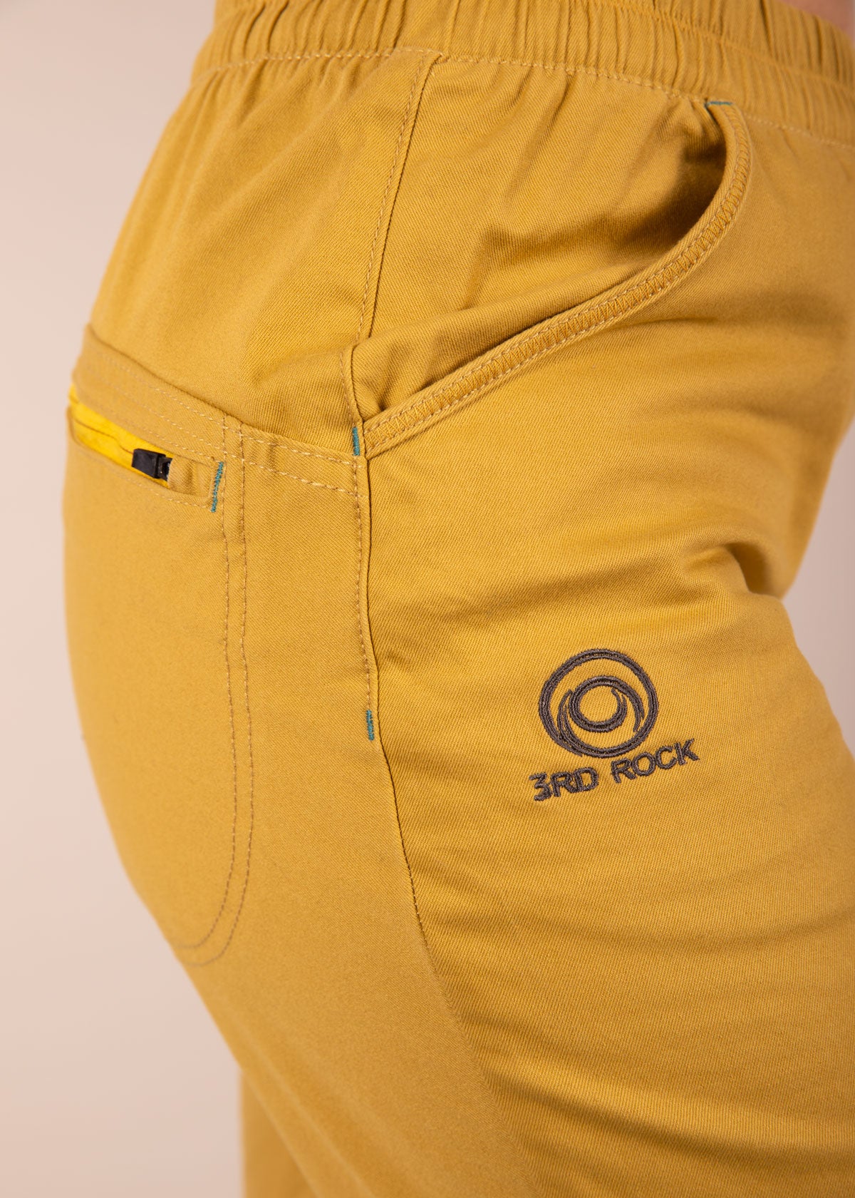 A close up of our thigh embroidered logo on the 3rd rock clothing margo trousers in honey badger
